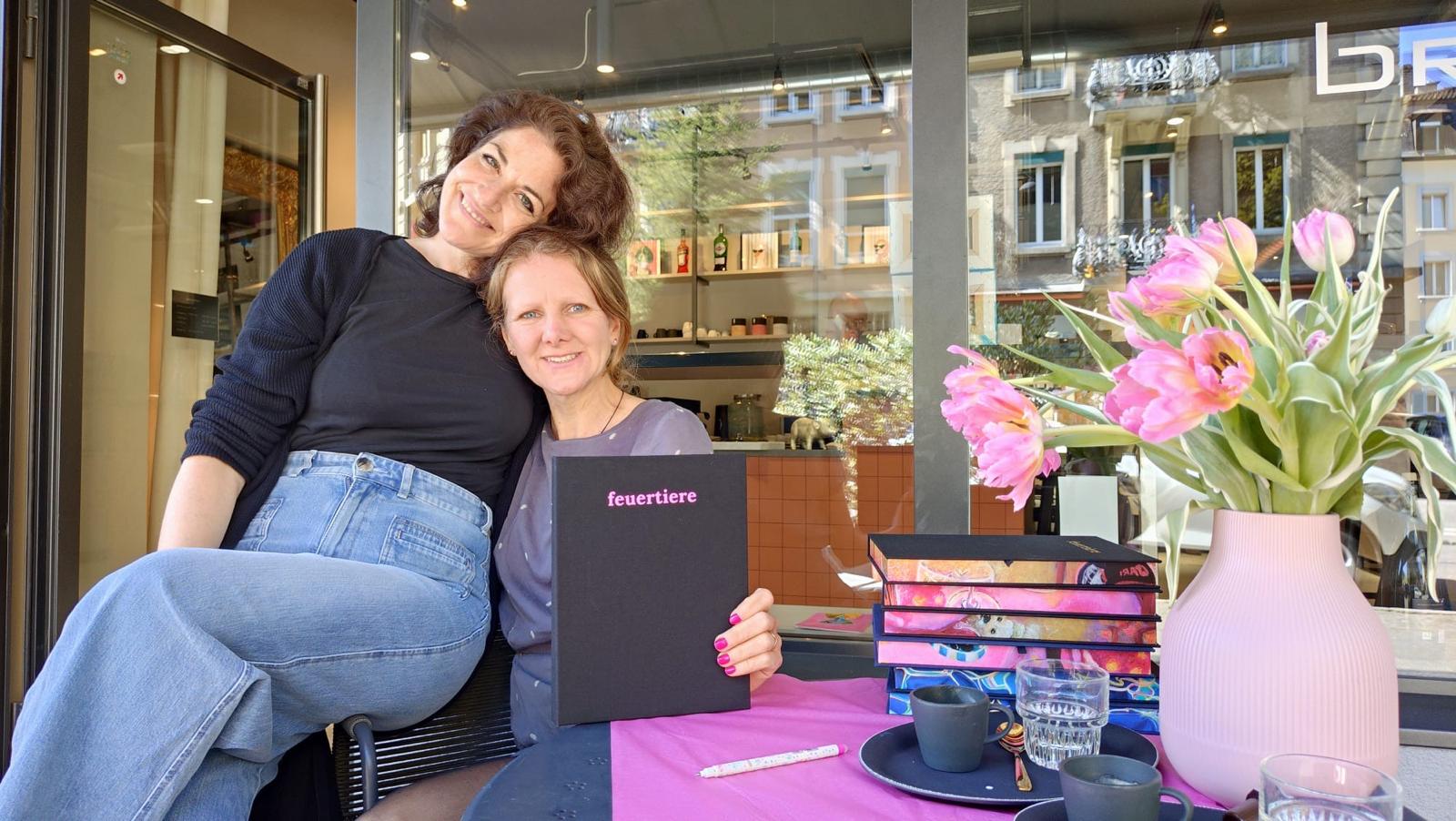 Miriam Ysa Calista und IWAWALL (Sarah Maurer) mit dem Kunstbuch feuertiere